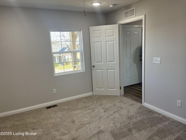 spare room featuring dark colored carpet