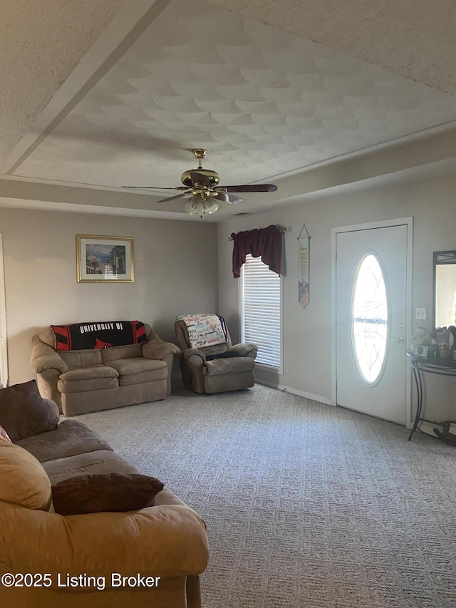 carpeted living area featuring ceiling fan and a textured ceiling