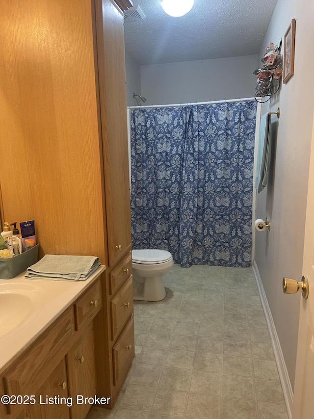 bathroom featuring vanity, a textured ceiling, toilet, and curtained shower