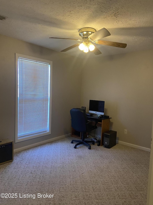 carpeted office featuring ceiling fan, baseboards, and a textured ceiling