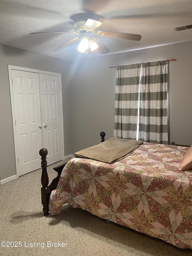 carpeted bedroom featuring ceiling fan, a textured ceiling, and a closet