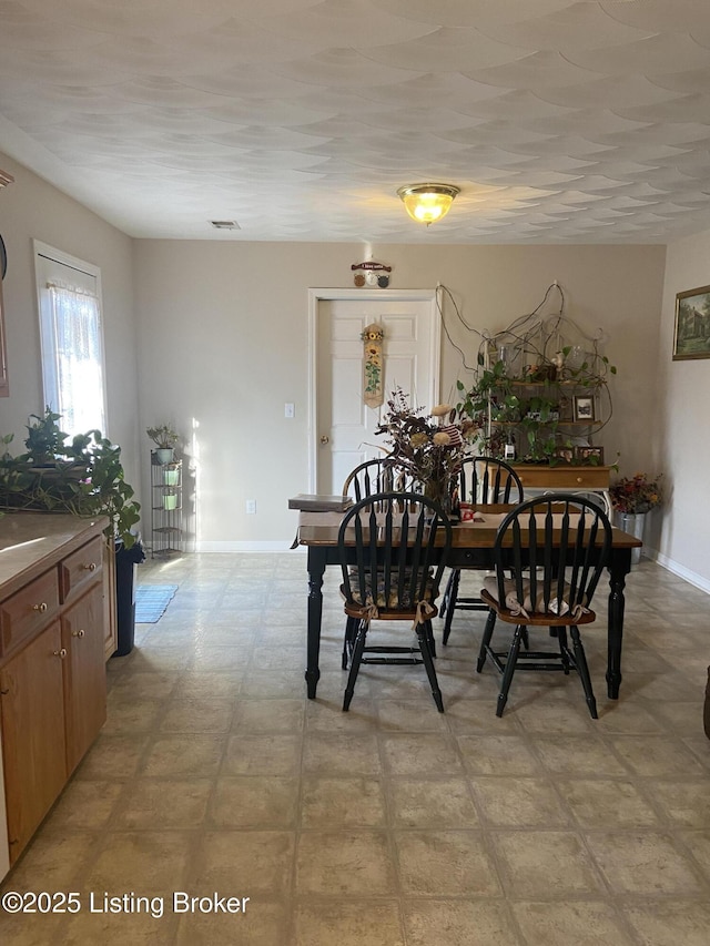 dining space with baseboards and light floors