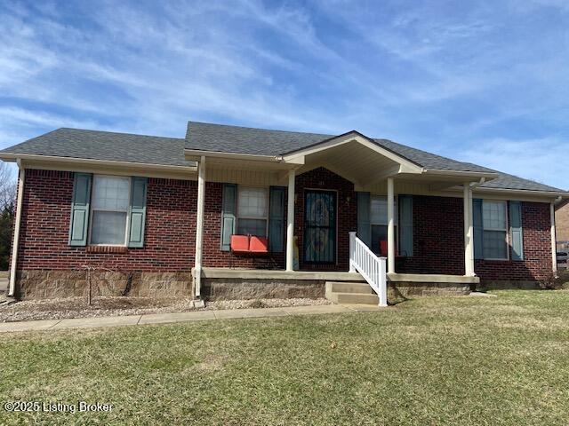 single story home featuring roof with shingles, brick siding, and a front lawn