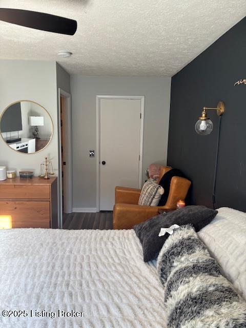 bedroom with a textured ceiling and dark hardwood / wood-style floors