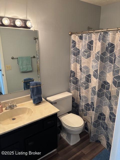 bathroom featuring hardwood / wood-style floors, vanity, a shower with shower curtain, and toilet