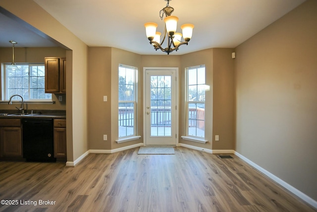 doorway featuring sink, dark wood-type flooring, and a notable chandelier