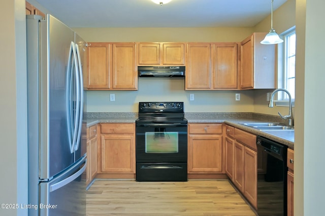 kitchen featuring sink, decorative light fixtures, light wood-type flooring, ventilation hood, and black appliances