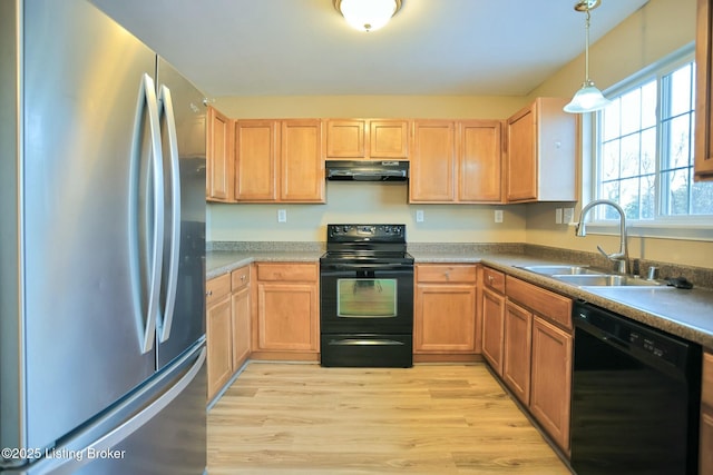 kitchen with decorative light fixtures, exhaust hood, black appliances, light wood-type flooring, and sink