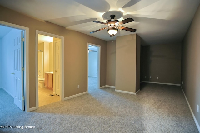 interior space with ceiling fan, ensuite bathroom, and light carpet