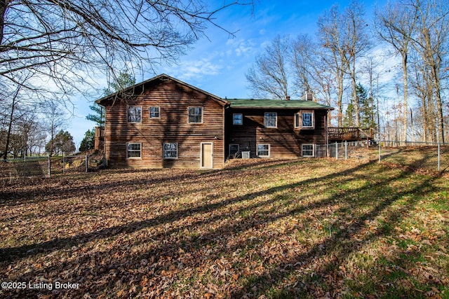 back of property featuring a wooden deck and a yard