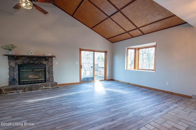 unfurnished living room with hardwood / wood-style floors, a stone fireplace, and ceiling fan