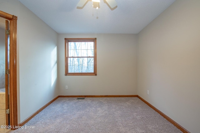 empty room featuring a textured ceiling, carpet floors, and ceiling fan