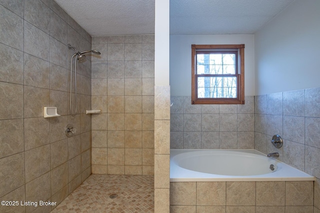 bathroom featuring a textured ceiling and separate shower and tub