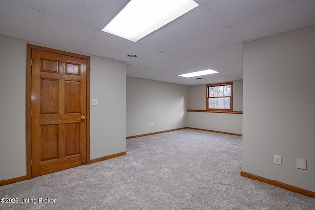 empty room with a paneled ceiling and light carpet