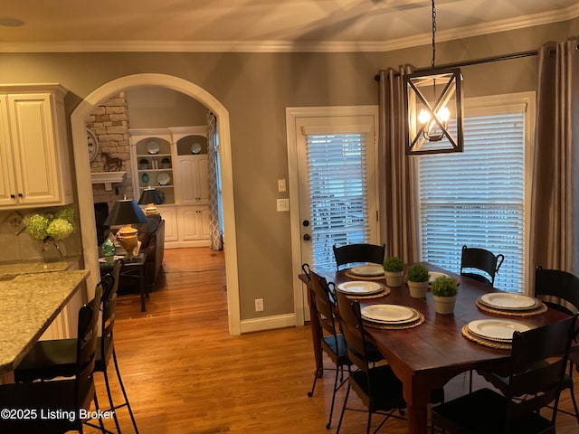 dining room featuring plenty of natural light, light hardwood / wood-style flooring, a notable chandelier, and ornamental molding