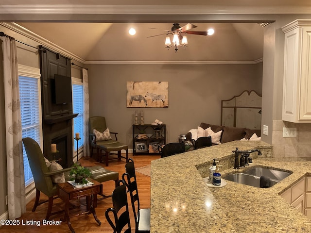 kitchen featuring sink, white cabinets, light stone counters, decorative backsplash, and lofted ceiling