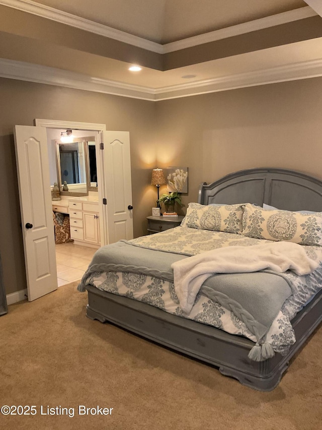 carpeted bedroom with ensuite bathroom and ornamental molding