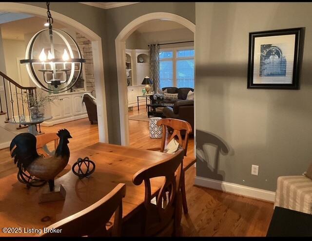 dining area with hardwood / wood-style floors and an inviting chandelier