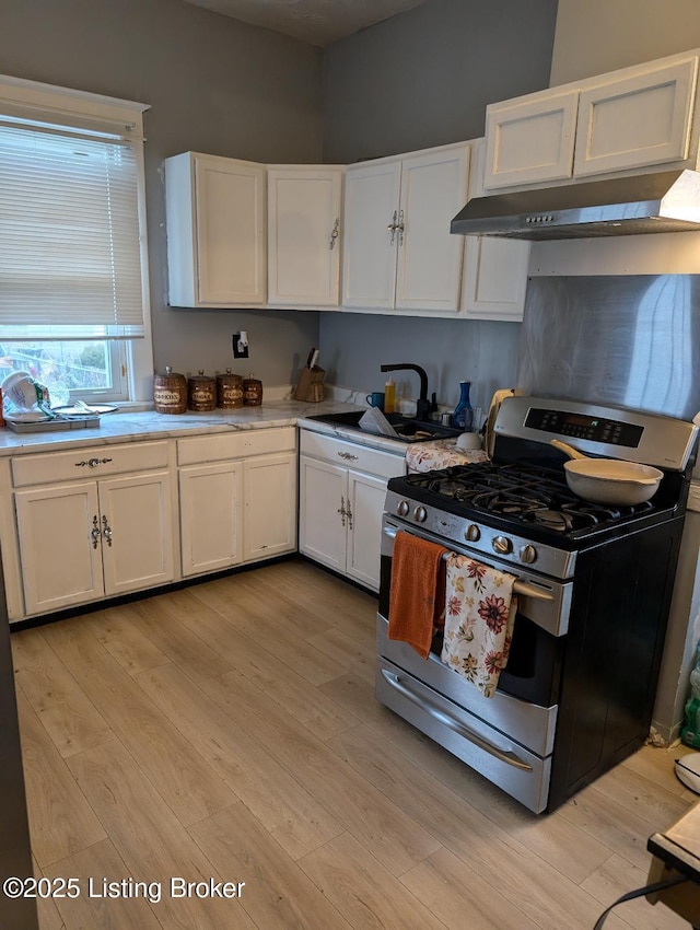 kitchen featuring white cabinets, sink, and stainless steel gas range