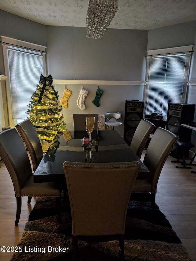 dining space with hardwood / wood-style floors and a chandelier