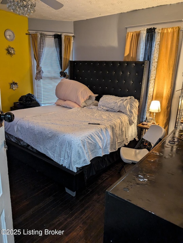 bedroom with ceiling fan, dark hardwood / wood-style floors, and a textured ceiling