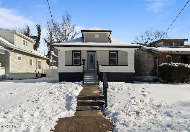 bungalow-style house with a porch and central AC unit