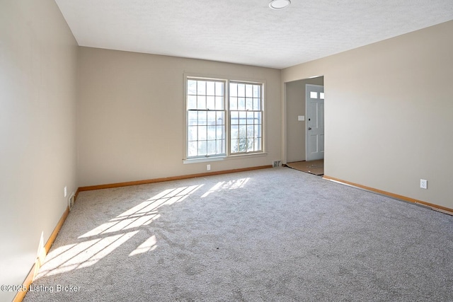 carpeted spare room featuring a textured ceiling