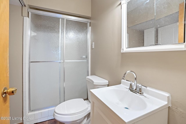 bathroom with vanity, toilet, and a shower with shower door