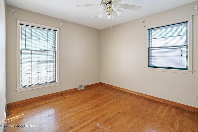 empty room with ceiling fan, a healthy amount of sunlight, and light wood-type flooring