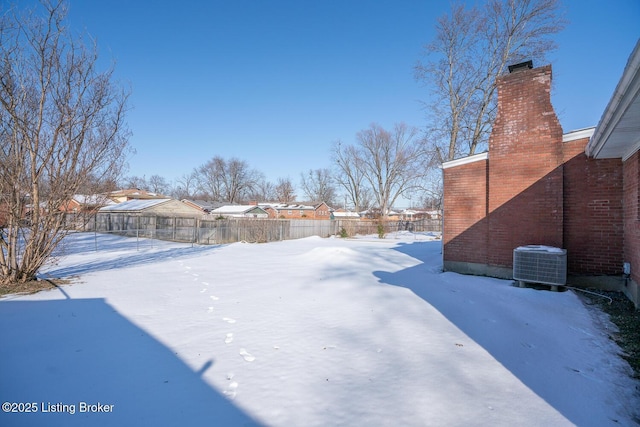 yard layered in snow featuring central AC unit