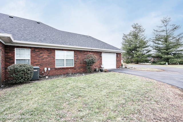 view of property exterior featuring a garage, central air condition unit, and a lawn