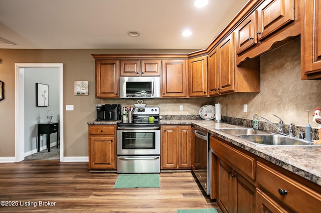 kitchen with stainless steel appliances, hardwood / wood-style flooring, sink, and backsplash