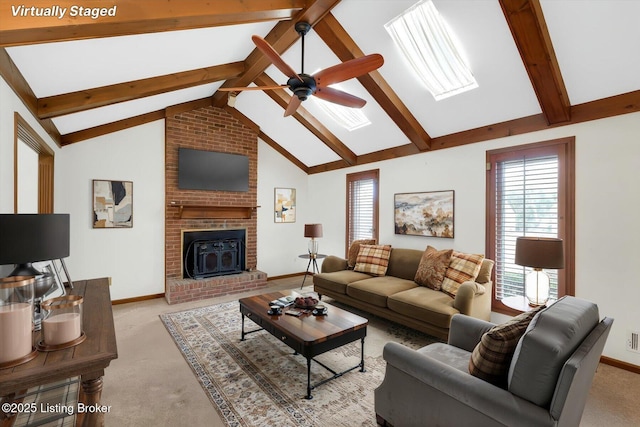 living room with a skylight, beamed ceiling, a healthy amount of sunlight, and light colored carpet