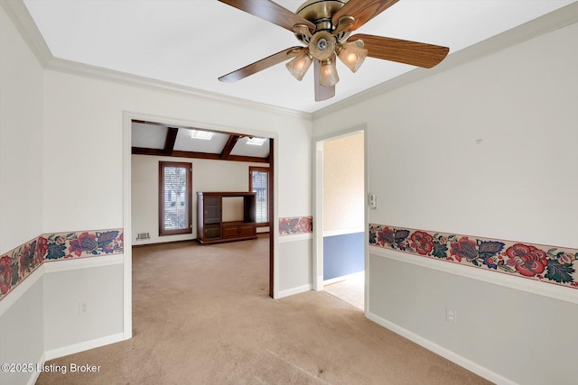 spare room with crown molding, ceiling fan, baseboards, light carpet, and beam ceiling