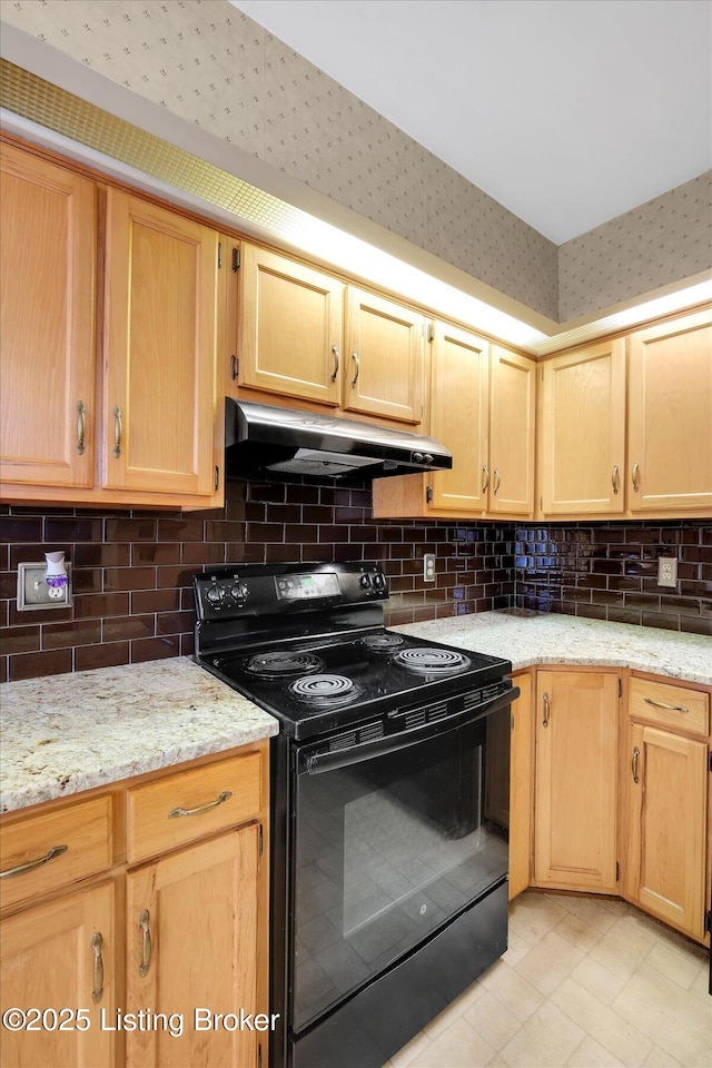 kitchen with black range with electric stovetop, light stone countertops, under cabinet range hood, light brown cabinetry, and decorative backsplash