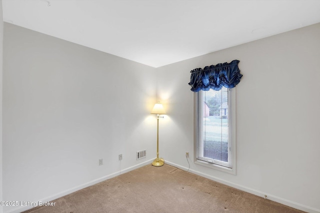 empty room featuring carpet flooring, baseboards, and visible vents