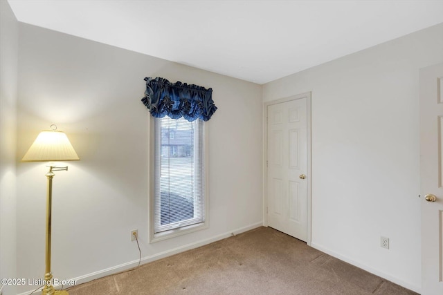 empty room with carpet and baseboards