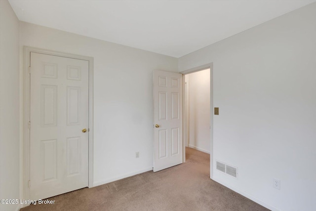 unfurnished bedroom featuring carpet flooring, baseboards, and visible vents