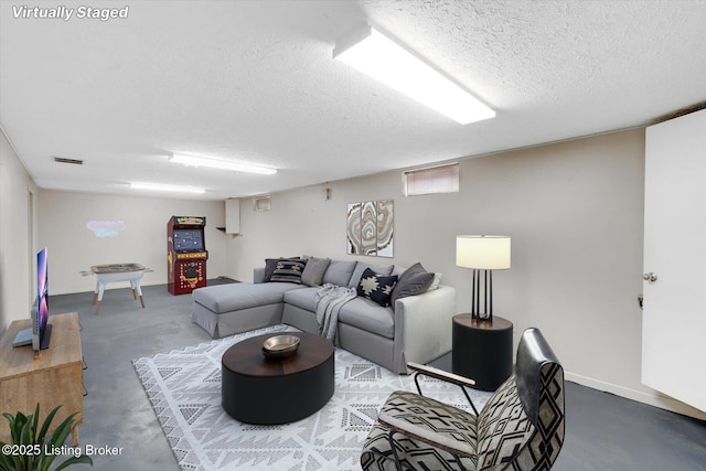 living area with visible vents, a textured ceiling, and concrete flooring