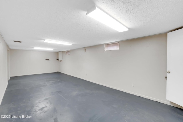 below grade area with visible vents, baseboards, and a textured ceiling