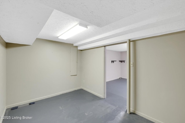 finished basement with baseboards and a textured ceiling