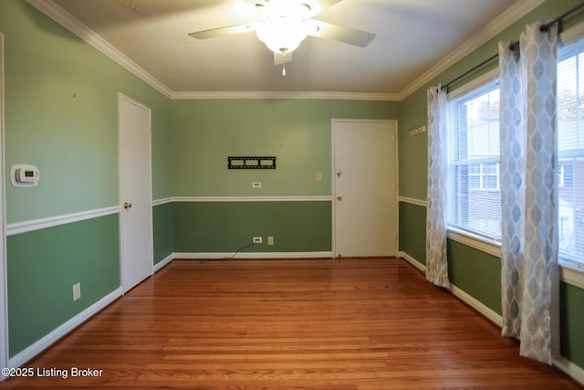 empty room with ceiling fan, ornamental molding, and hardwood / wood-style floors