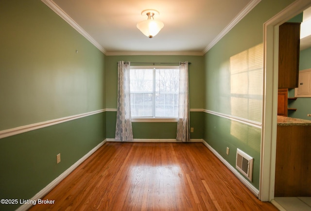 spare room featuring crown molding and hardwood / wood-style flooring