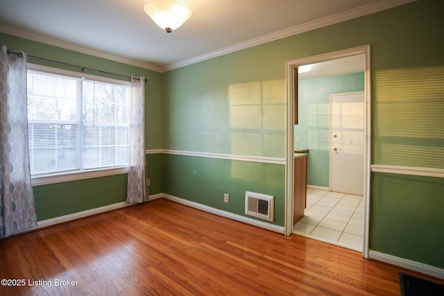 unfurnished room with light hardwood / wood-style floors and crown molding