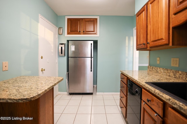 kitchen with dishwasher, stainless steel refrigerator, light stone countertops, sink, and light tile patterned flooring