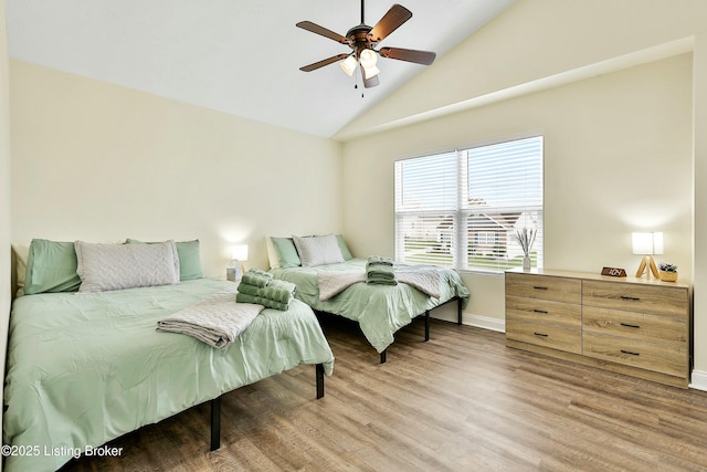 bedroom featuring ceiling fan, wood-type flooring, and lofted ceiling