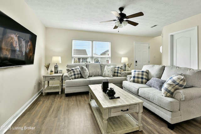 living room with ceiling fan, dark hardwood / wood-style flooring, and a textured ceiling