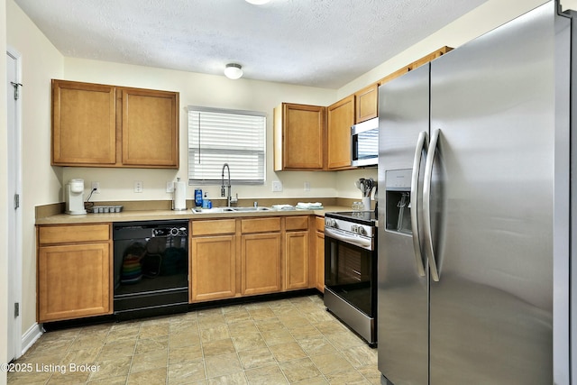 kitchen featuring a textured ceiling, sink, and appliances with stainless steel finishes