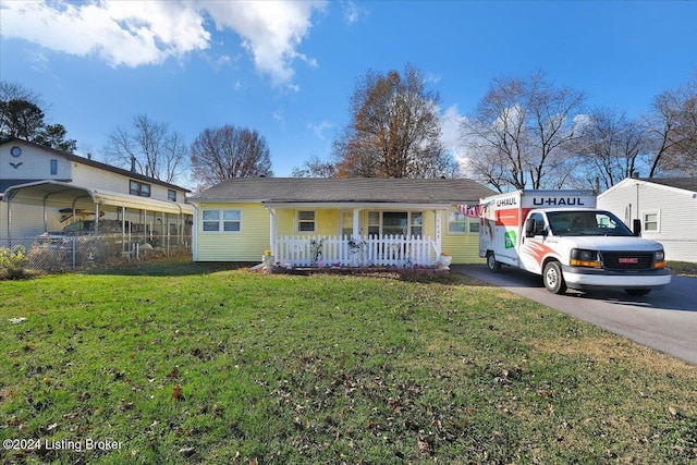 single story home with covered porch, a carport, and a front yard