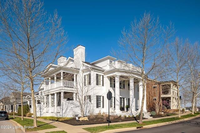 neoclassical home featuring a balcony